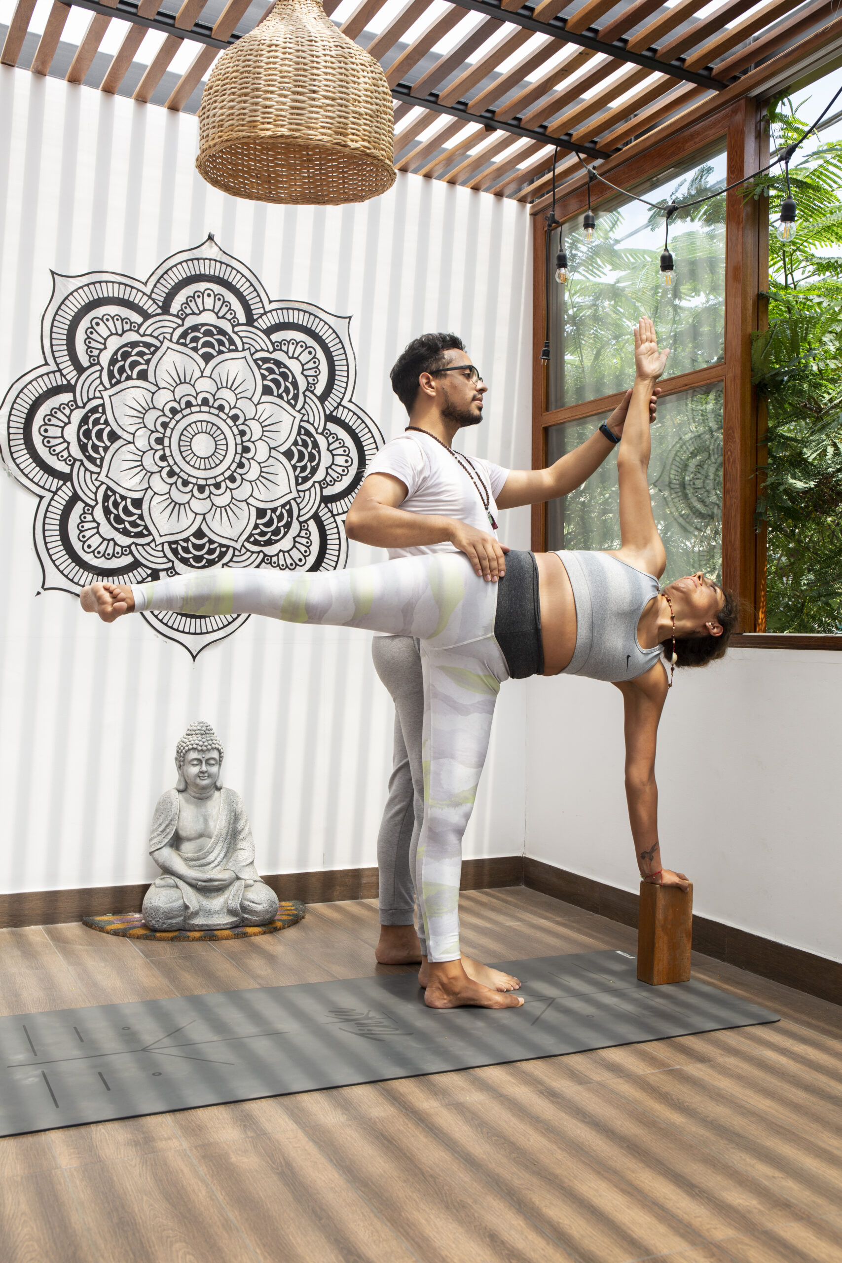 Profesor de Yoga guiando a la alumna.